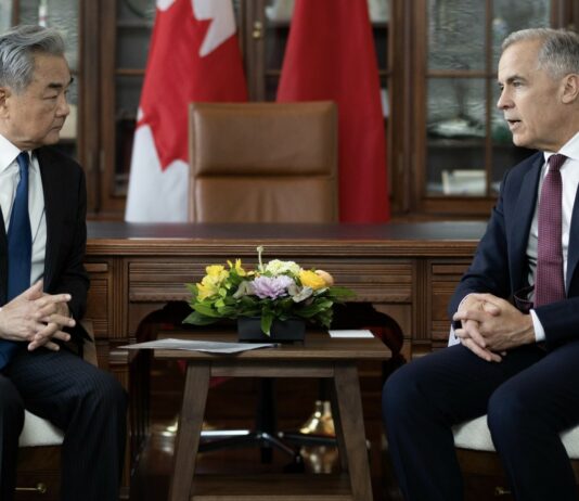 Chiny i Kanada odbudowują kanały rozmów. Wang Yi spotkał się z Markiem Carneyem Wang Yi i Mark Carney podczas spotkania w Ottawie na tle flag Chin i Kanady