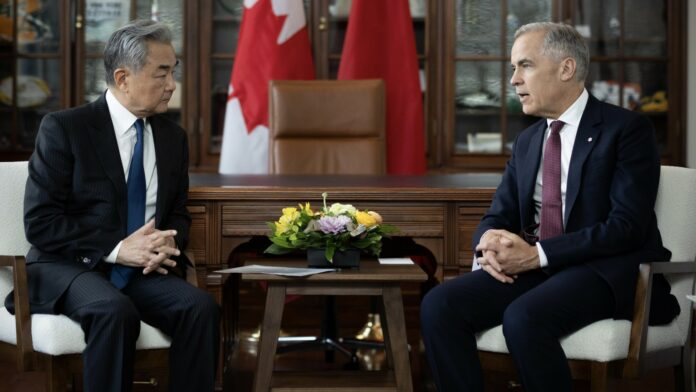 Wang Yi i Mark Carney podczas spotkania w Ottawie na tle flag Chin i Kanady