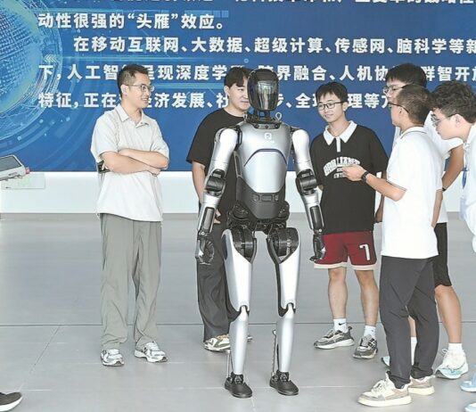 Od AI po robotykę. Chiny przebudowują uczelnie pod nowe technologie Nowe kierunki studiów w Chinach – studenci przy robocie humanoidalnym podczas otwarcia Kolegium Sztucznej Inteligencji w Guangxi