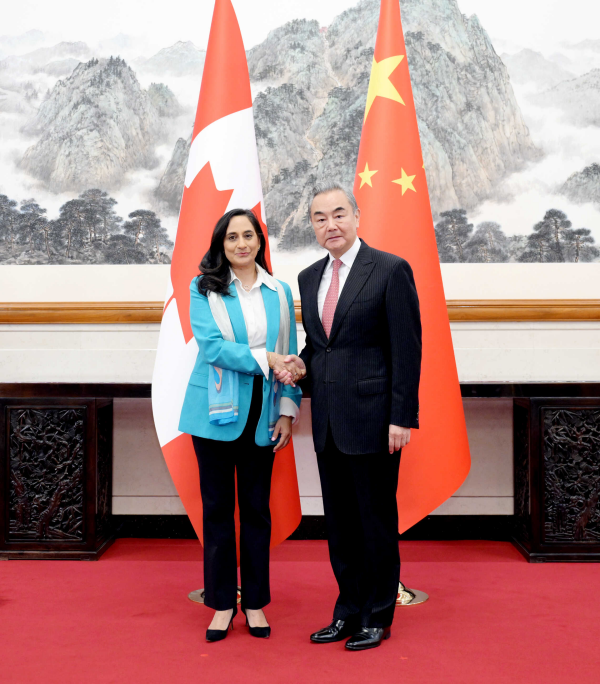 Wang Yi i Anita Anand podczas spotkania na tle flag Chin i Kanady