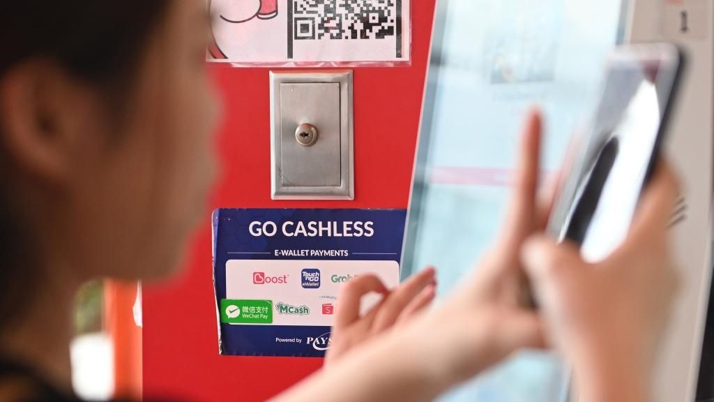 wechat-pay-kuala-lumpur-malezja-platnosci-mobilne-chiny-xinhua Tabliczka z logo WeChat Pay i informacją o płatnościach bezgotówkowych w sklepie w Kuala Lumpur w Malezji.