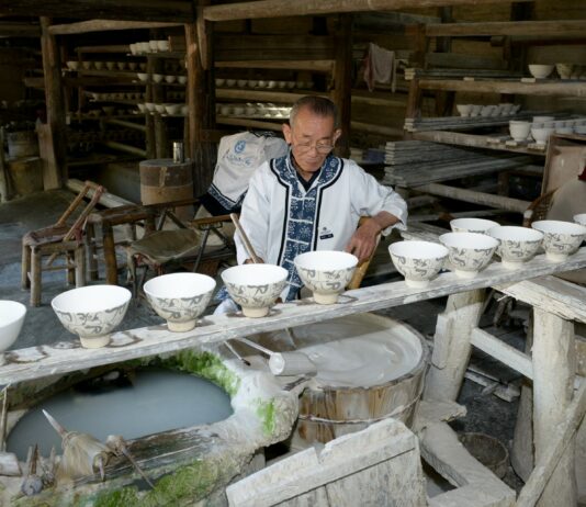 Jingdezhen na Liście UNESCO – tysiąc lat porcelany z gliny, ognia i ludzkiej ręki Rzemieślnik zdobi porcelanowe czarki w tradycyjnym warsztacie w Jingdezhen