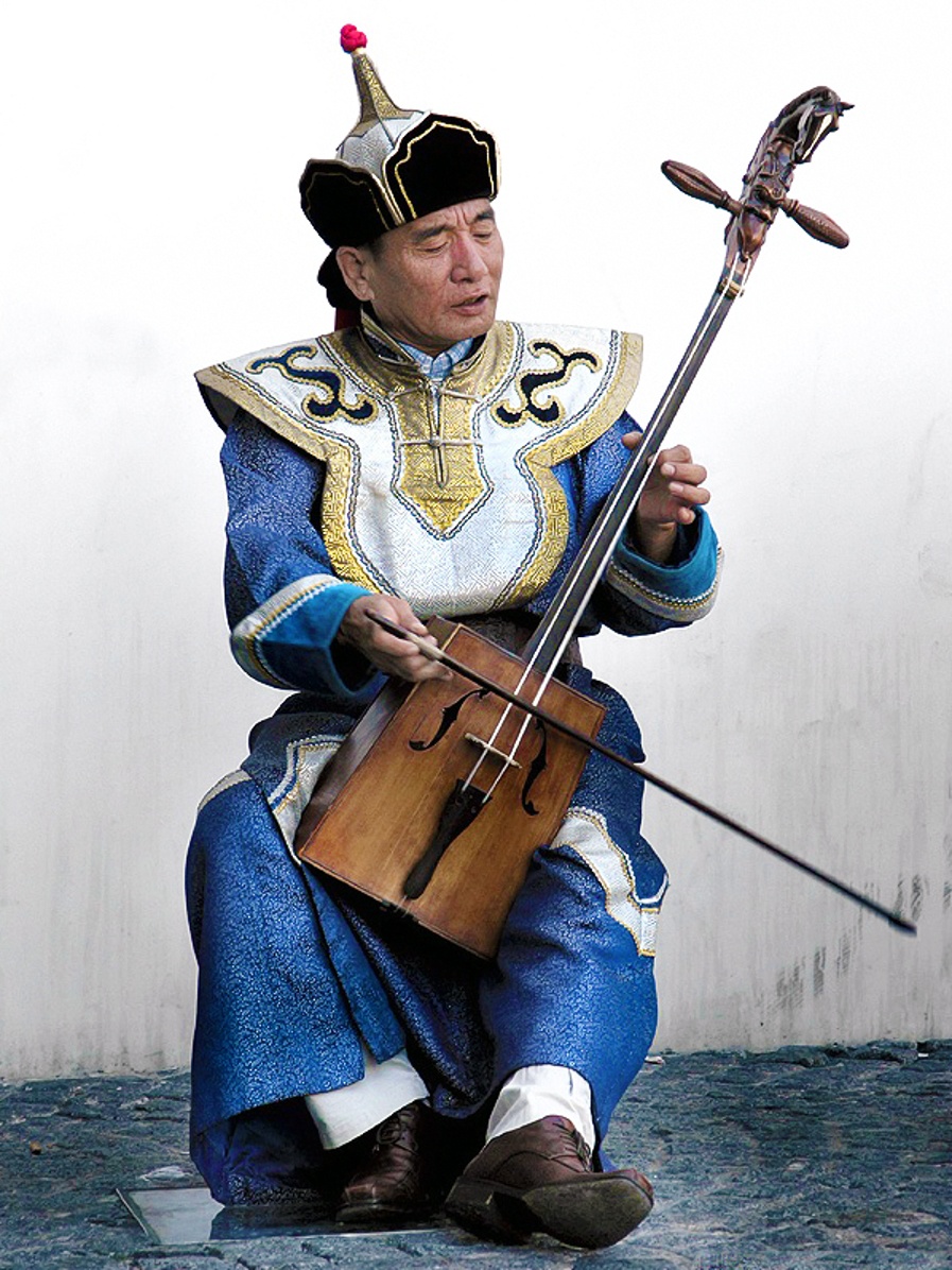 Muzyk gra na matouqin, mongolskim instrumencie smyczkowym z głową konia