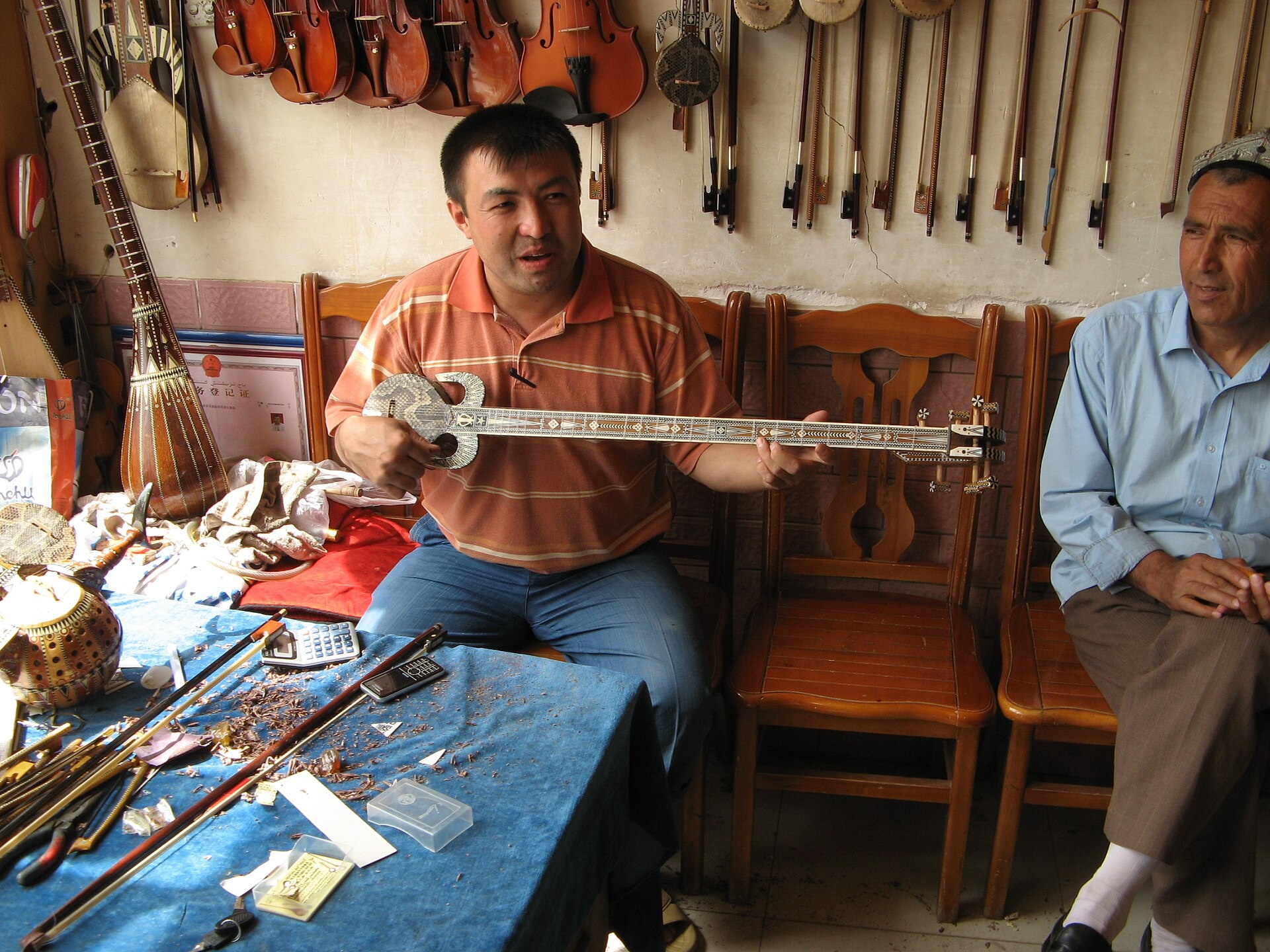 Muzyk w Kaszgarze prezentuje rewapu, ujgurski instrument strunowy