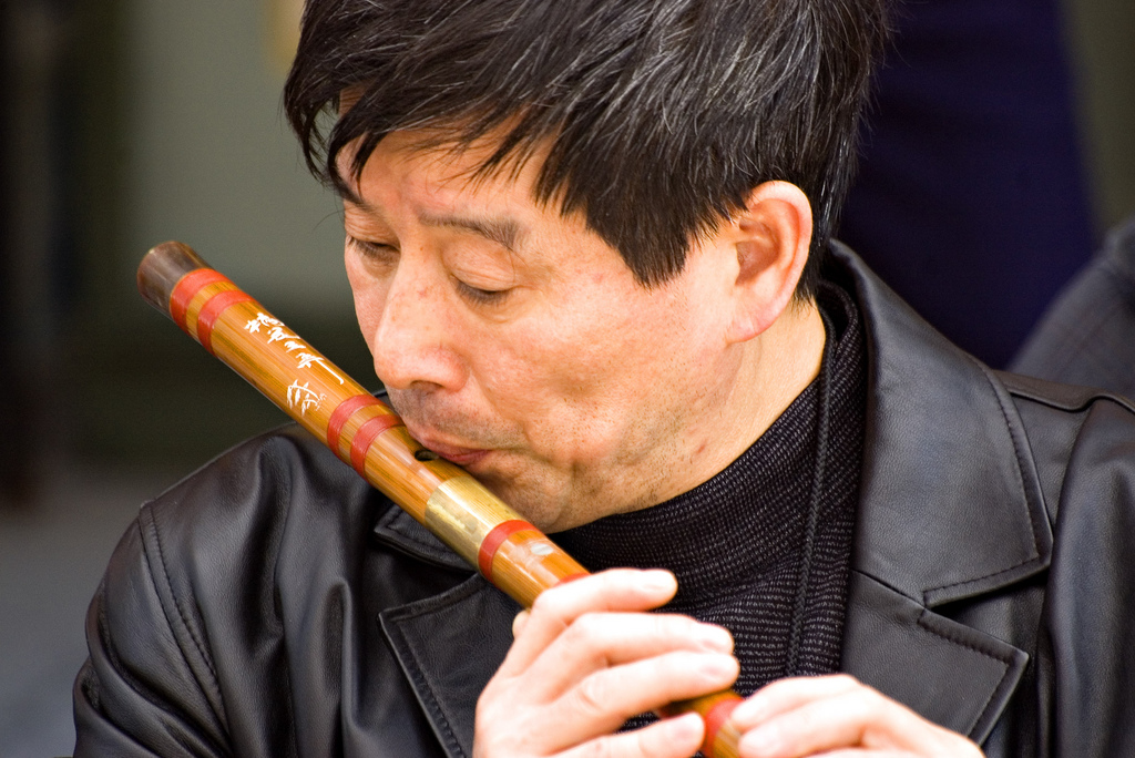 Tradycyjne instrumenty muzyczne Chin – muzyk grający na poprzecznym bambusowym flecie dizi