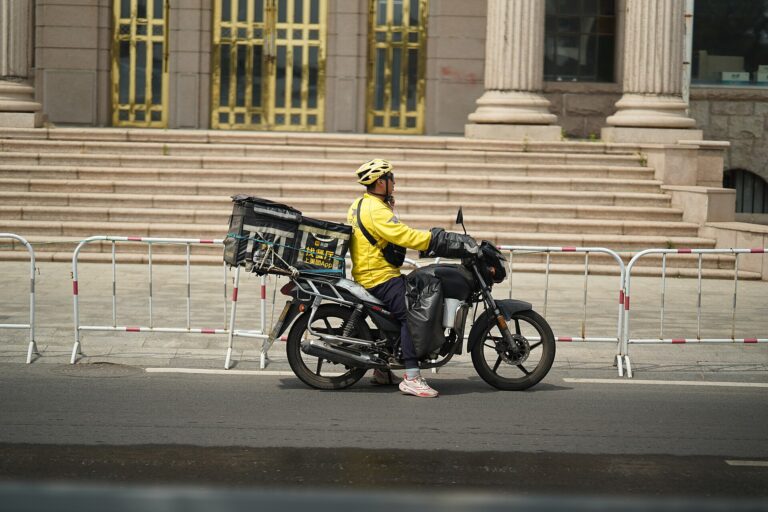 Kurier Meituan na motocyklu w Qingdao