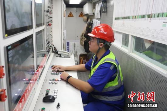 Operator w czerwonym kasku steruje maszyną drążącą podczas budowy tunelu pod Zatoką Jiaozhou.